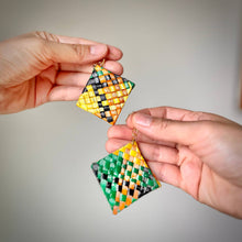 Load image into Gallery viewer, Hand holding two geometric patterned earrings against a neutral background