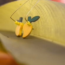 Load image into Gallery viewer, mango shape wooden earrings with brass hook on green leaf background
