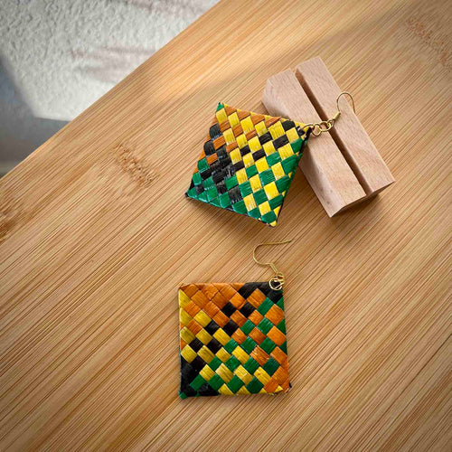 Woven square earrings on a wooden surface