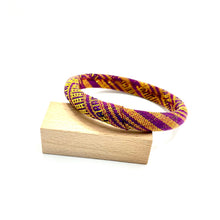 Load image into Gallery viewer, Woven purple and yellow bracelet on a wooden block with a white background
