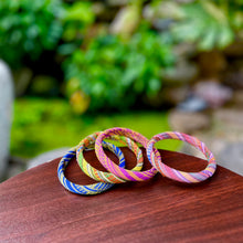 Load image into Gallery viewer, Colorful bangles on a wooden surface with a blurred green background
